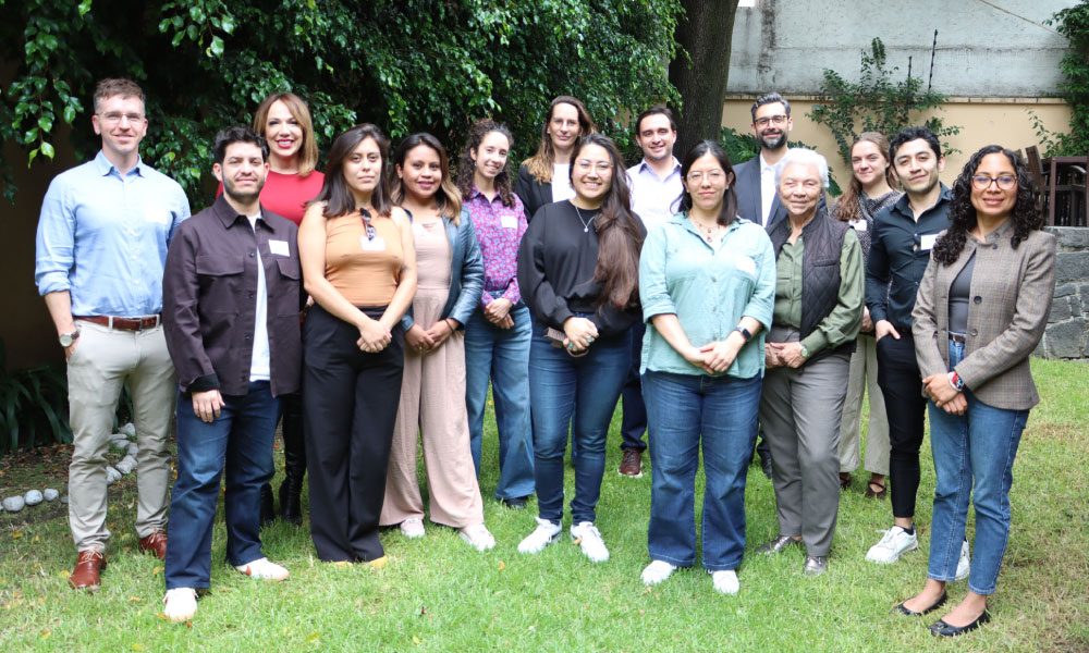 A group of colleagues posing for a photo outdoors.